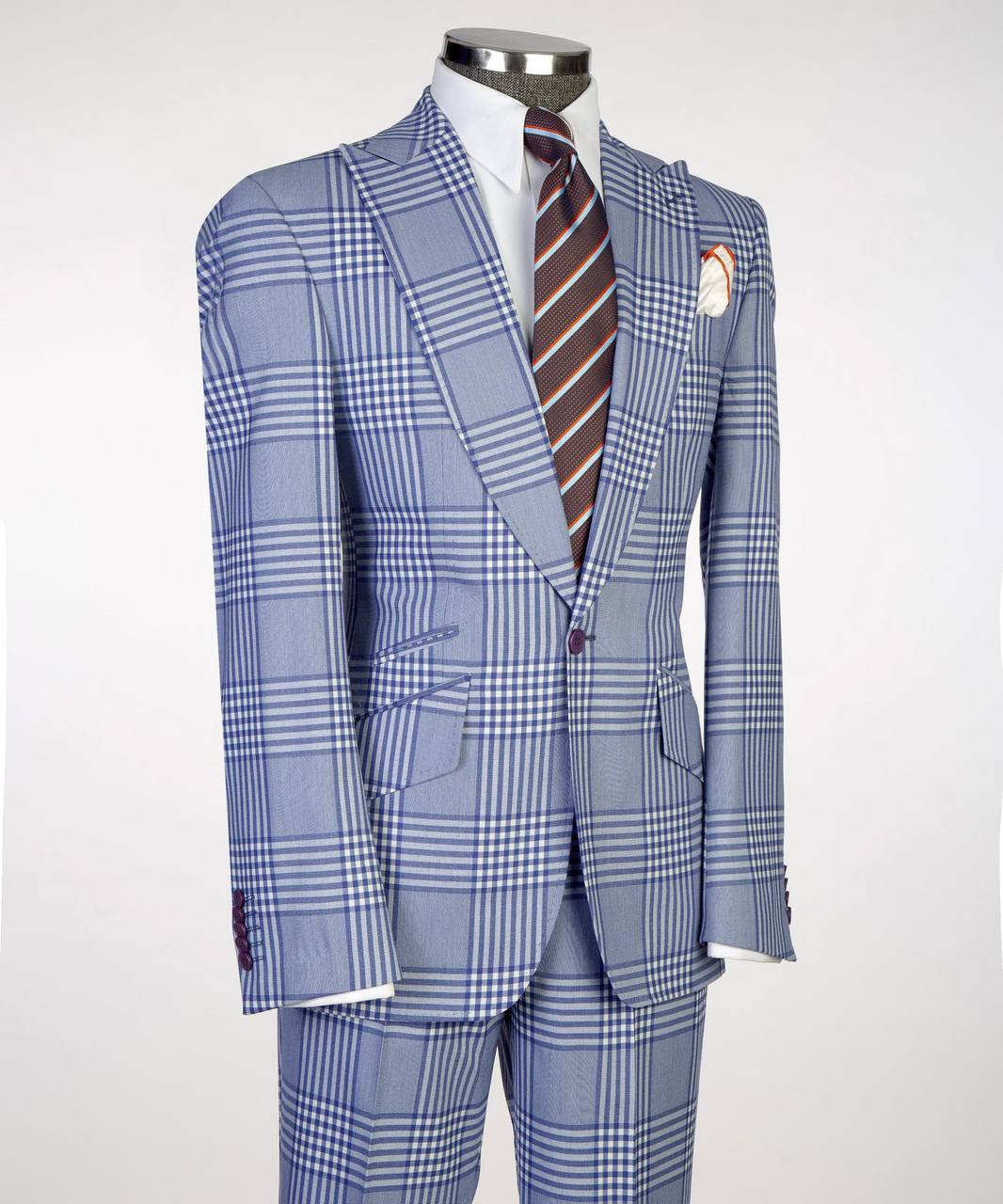 Light blue plaid men’s suit on mannequin with white shirt, striped tie, and pocket square.