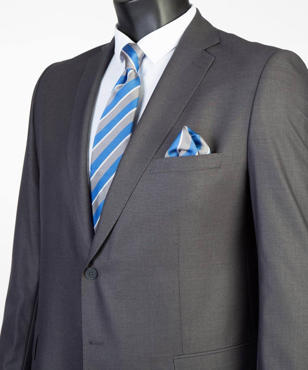 Close-up of charcoal Super 200’s wool suit jacket with blue striped tie styling